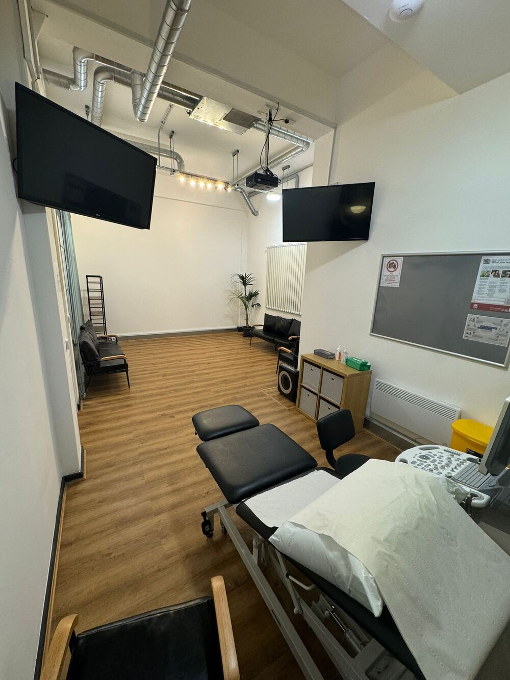 Modern private ultrasound scan room with comfortable bed, ultrasound equipment, and warm ambient lighting