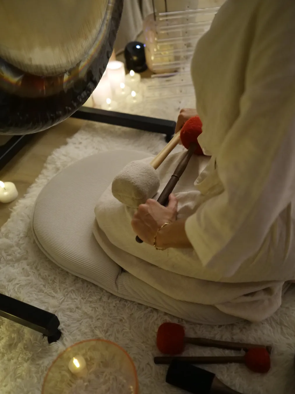 Hands playing a Tibetan singing bowl during a sound massage