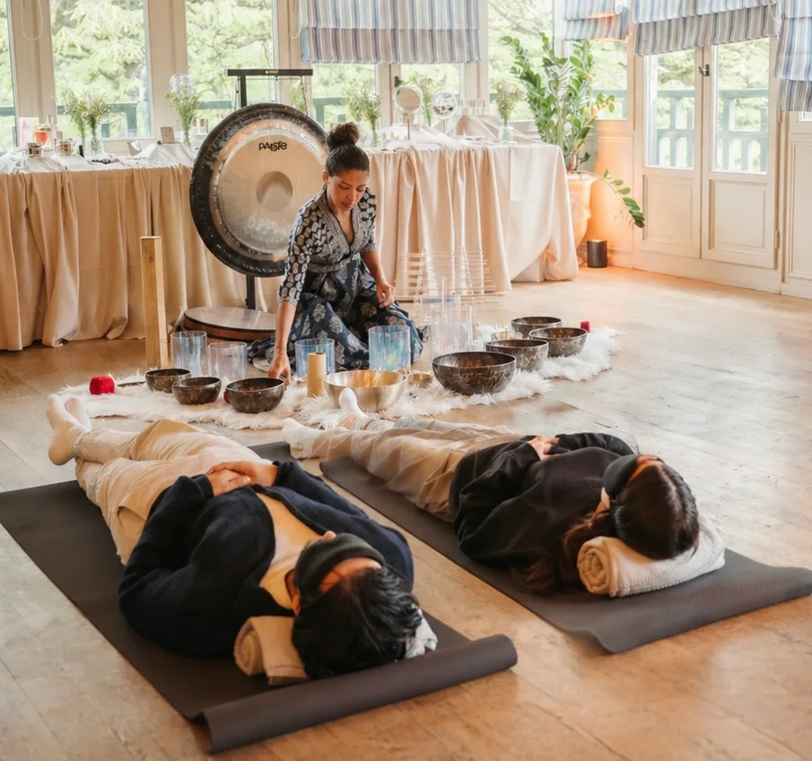 Bain sonore en petit groupe dans une salle lumineuse, praticienne installée au gong