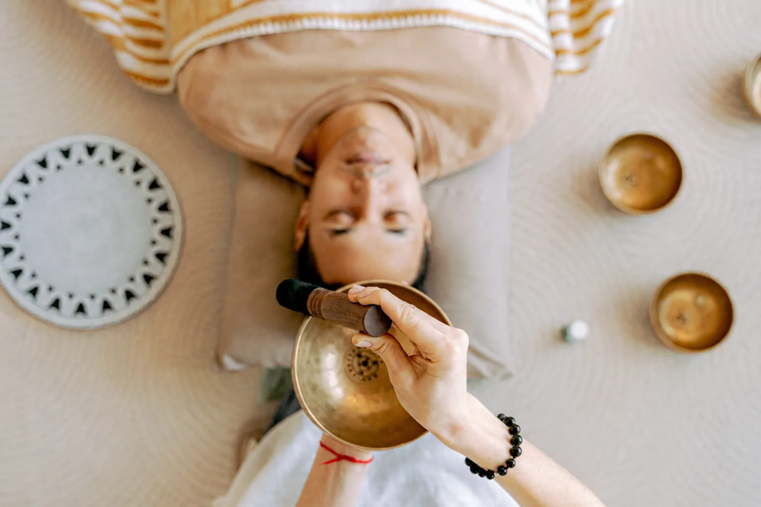 Person lying down during a private session, singing bowl resting on the chest, Résonance studio