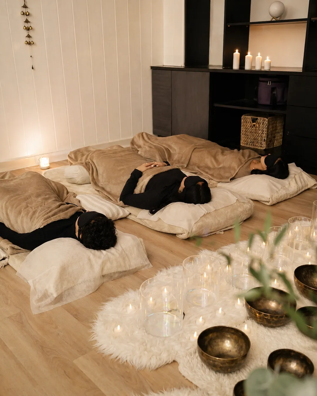 Participants lying down during a candlelit sound bath