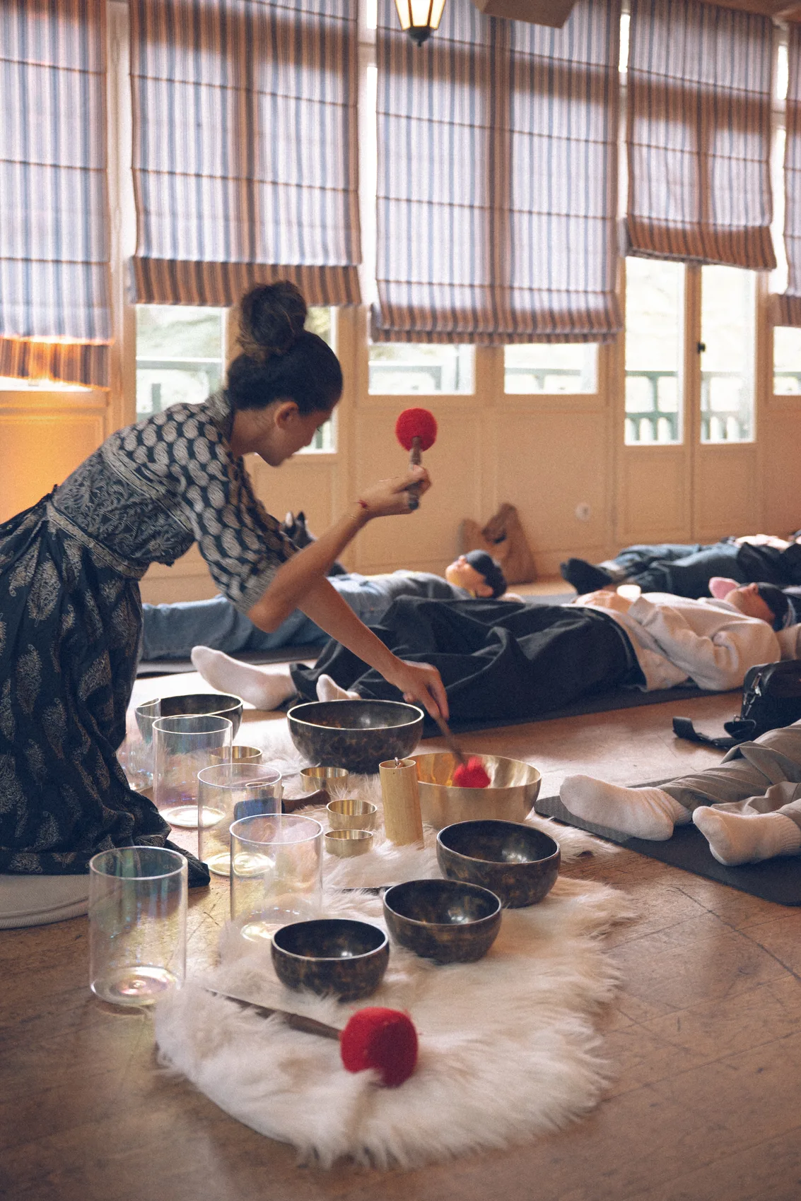 Bain sonore collectif du soir : participants allongés, bols au premier plan, studio Résonance